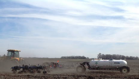 Tractor pulling an anhydrous applicator in a field