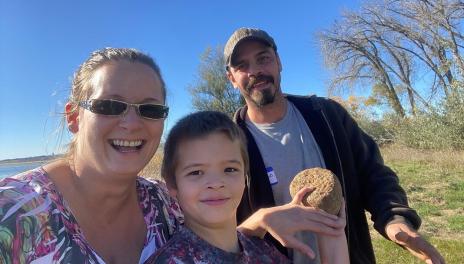 A family holds a rock found at nearby waterway