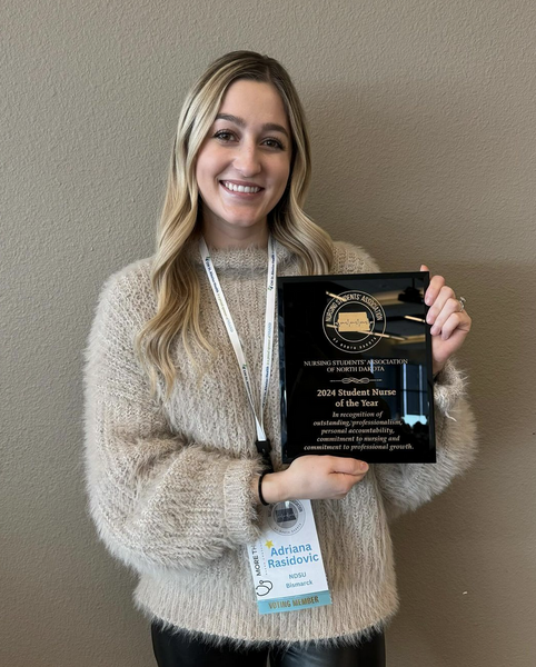 Photo of Adriana Rasidovic holding a plaque showing her award for ND Student Nurse of the Year