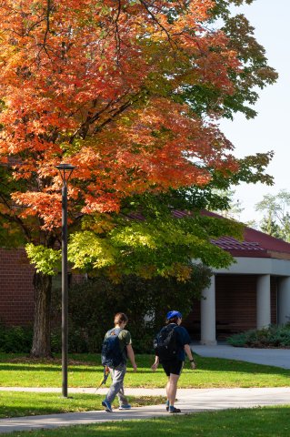 Two students walking on campus in the fall