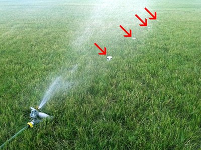 Lawn sprinklers with cups spaced in increasing distance from sprinkler head