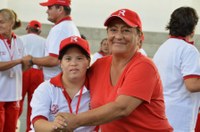 A grandmother and her grandson in baseball uniforms hug