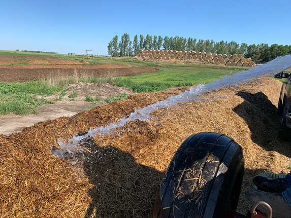 Figure 5. Watering compost at the Carrington Research Extension Center during an extremely dry period. (photo NDSU Carrington Research Extension Center)