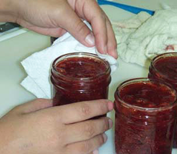 Wiping jar rims after filling.