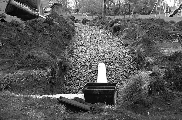 Figure 12. Gravel-filled trench with plastic drop box in the foreground.