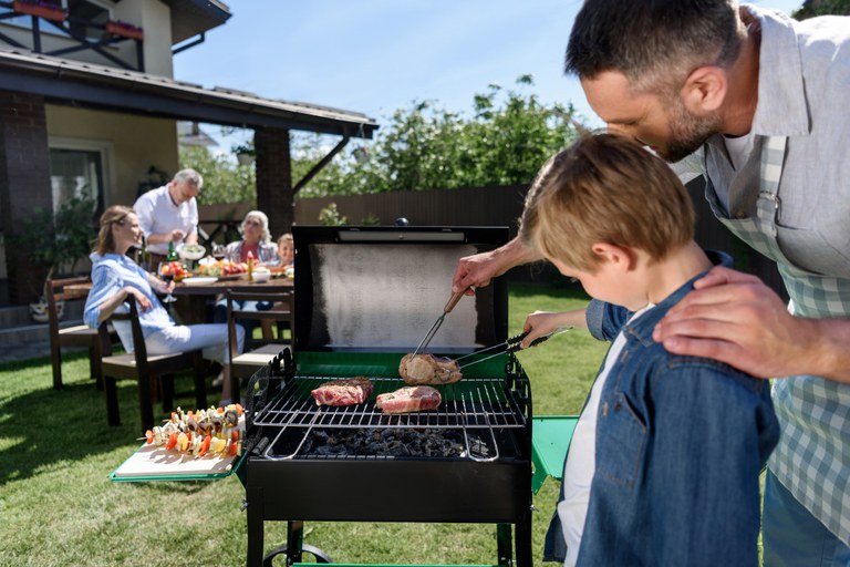 Man and Boy grilling on the barbecue