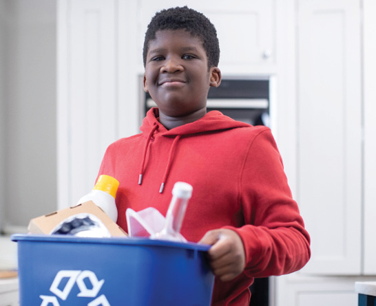 young smiling boy moving recycling container