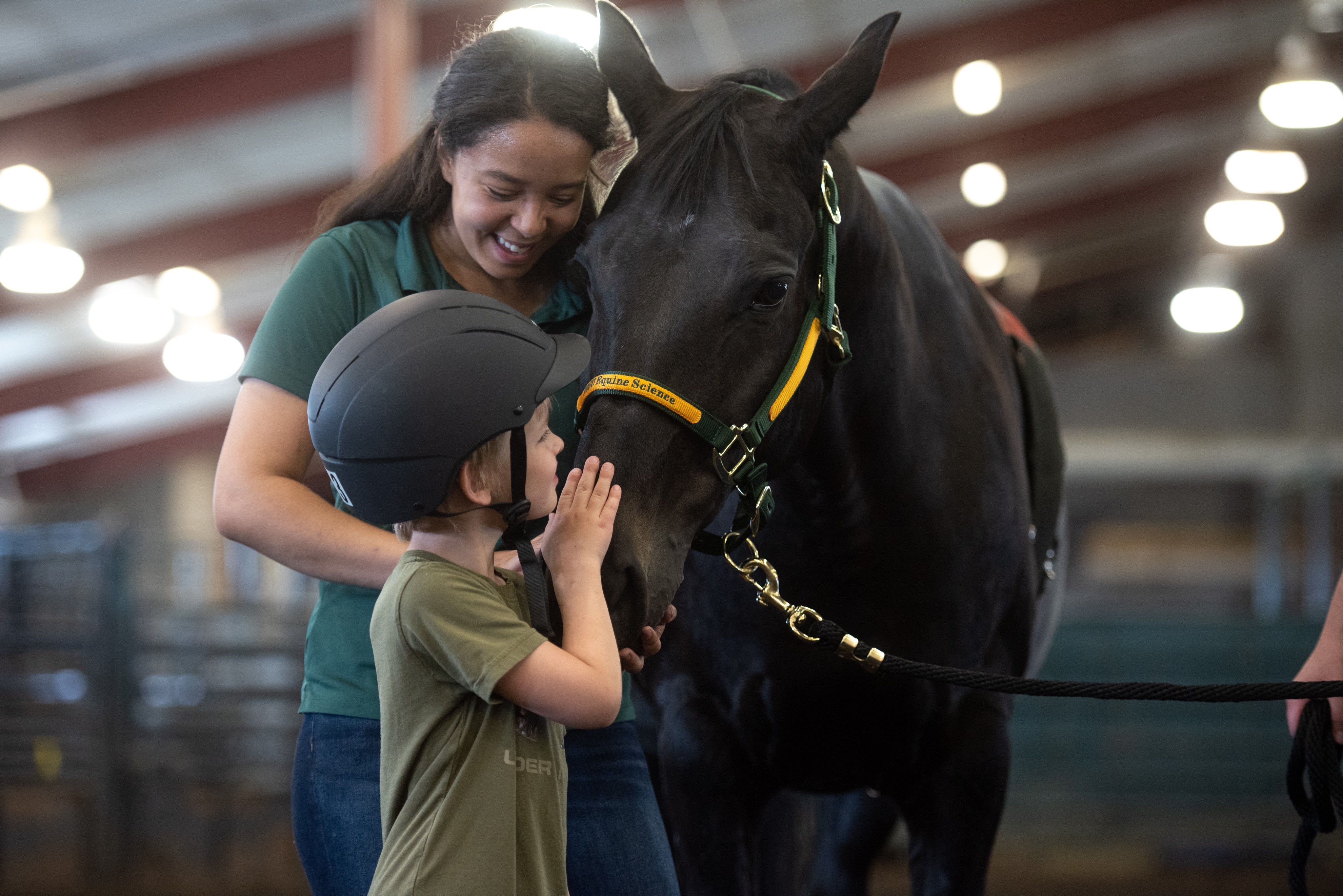 woman and child petting a horse's face