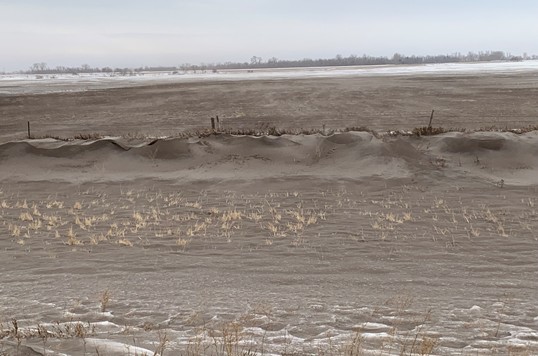 A roadside ditch full of topsoil from the adjoining field that was tilled in the fall. Picture taken on December 19, 2021 5-6 miles west of Grand Forks, ND along Highway-2.