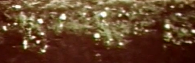 Figure 15.11 Single disc incorporation of UV sensitive spray operating at 6mp. The solid imposed white line near the top of the image shows the soil surface. Note a large portion of dye (white circles) near the soil surface (Elanco, ca. 1970)