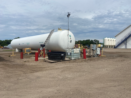 Figure 28.2 Ammonia storage at retail fertilizer dealer location, Arthur Companies, Arthur, ND. Note the black tanks used for emergency water storage the concrete barriers that prevent plumbing accidents from vehicles, the multiple pressure relief valves on storage tank top, and all of the proper signage prominently displayed on the tank. The platform for loading nurse tanks is on the opposite side. Image used with permission.