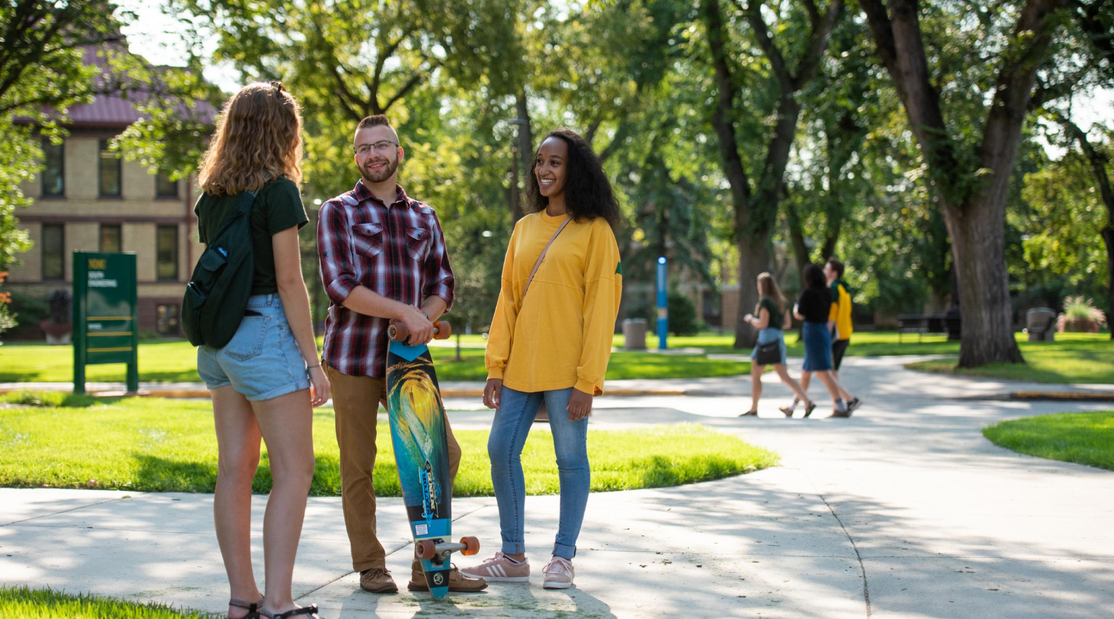 three students talking to each other on campus