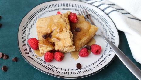 plate of 2 pancake squares with syrup and raspberries