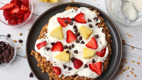 Peanut Butter Granola Breakfast Pizza with strawberries, pineapple and chocolate chips