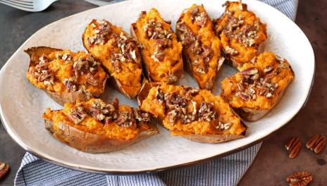 platter of sweet potato halves with pecans and maple syrup