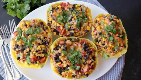 Spaghetti squash halves on platter with burrito toppings