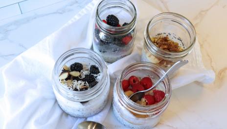 four jars with oatmeal and assorted toppings