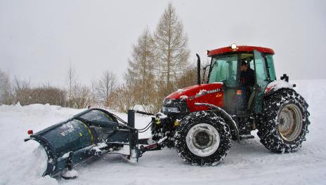 red tractor plowing snow