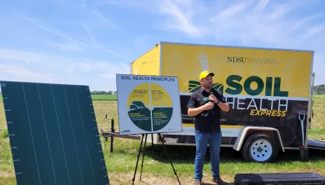 Carlos Pires stands in front of the Soil Health Express trailer.