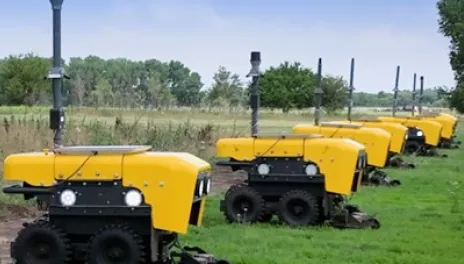 Yellow ag bots parked at the end of crop rows.