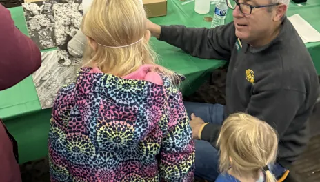 An NDSU Extension specialist talks to youth by an animal pen.