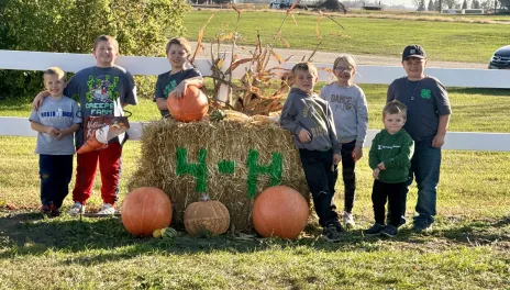 4-H'ers on a hay bale.