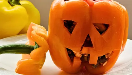 A bell pepper carved like a jack-o’-lantern.