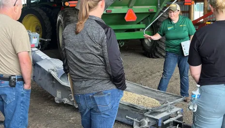 People gather around farm equipment.