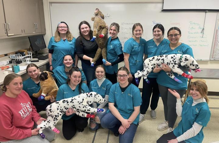 students in scrubs posing with stuffed animal dalmations 