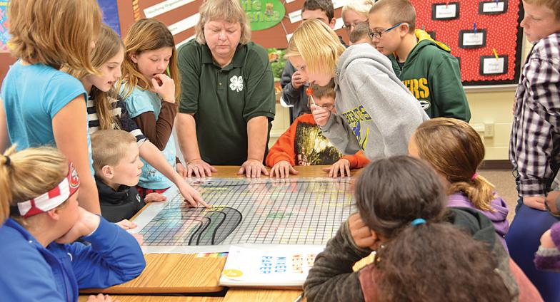 A 4-H volunteer leads a group of kids through a science experiment.