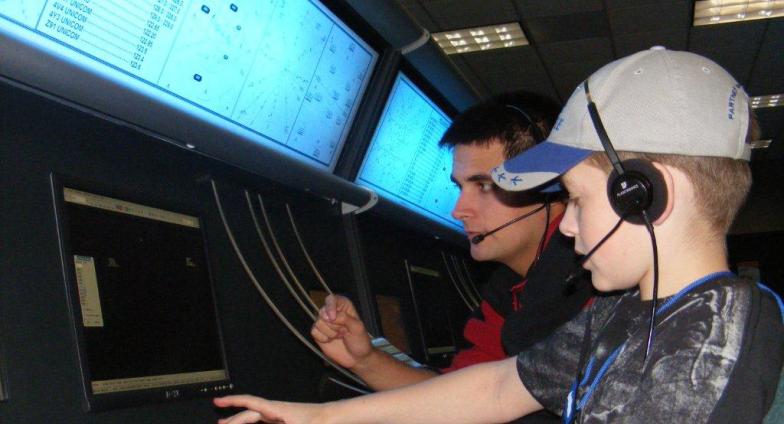 child at computer doing flight simulation with instructor