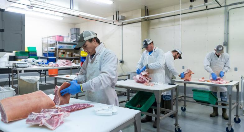 men cutting meat at NDSU Meat Lab