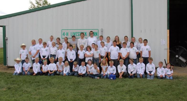 4-H youth posting for picture in front of livestock building