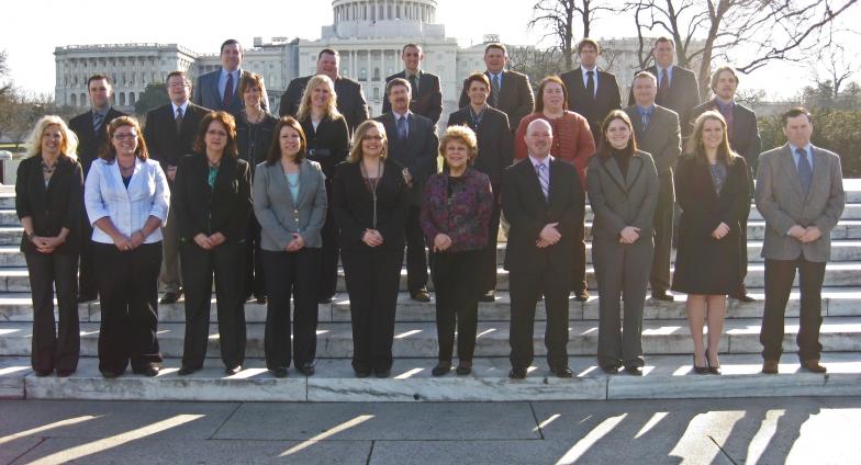 men and women posing in front of U.S. Capitol building