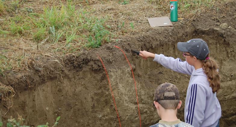 two youth identifying layers of soil in land judging competition