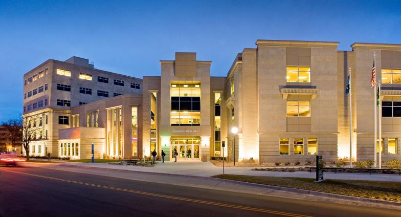 Ricahrd H. Barry Hall, a large building of light-colored cut stone, is pictured at night. 