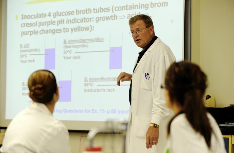 man in a lab coat teaching a class