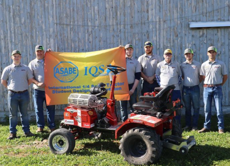 students pose with a tractor they built