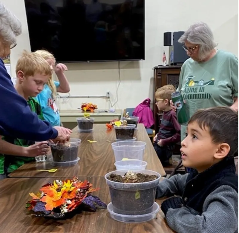 children and senior citizens pot flowers together