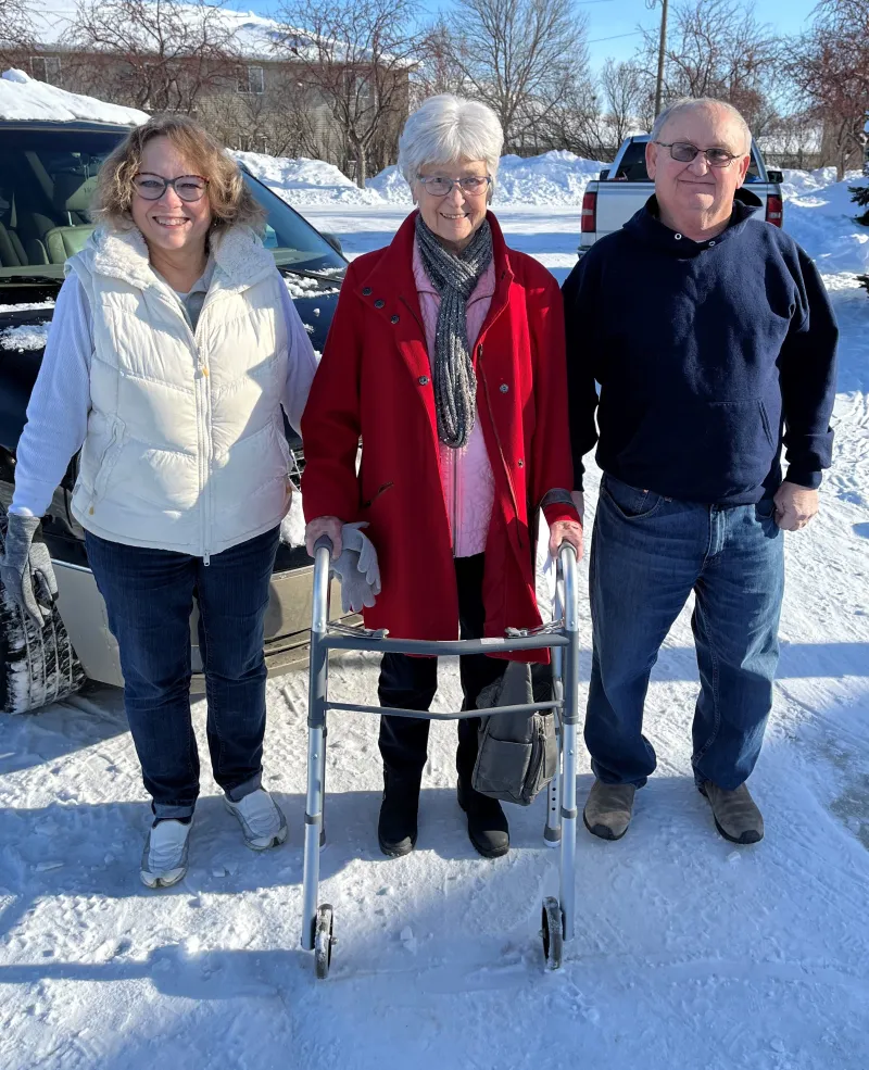 women with a walker in between two adults