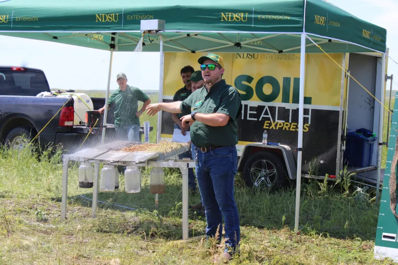 A man doing a soil health demo outdoors