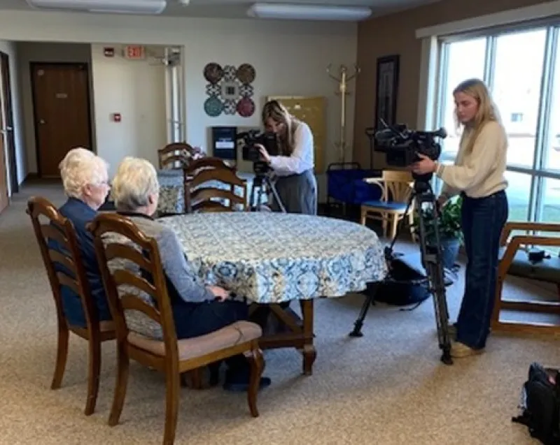 two senior citizens giving a TV interview