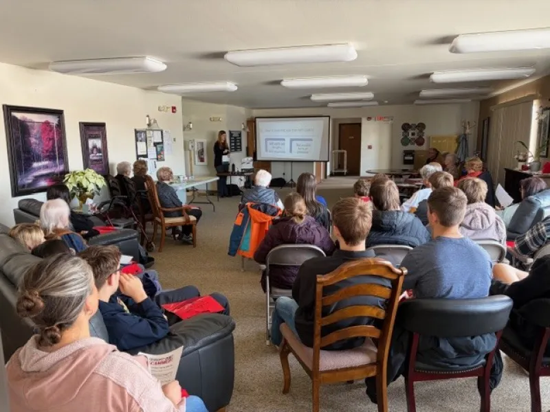 senior citizens listening to a presenter who teaches how to avoid scams