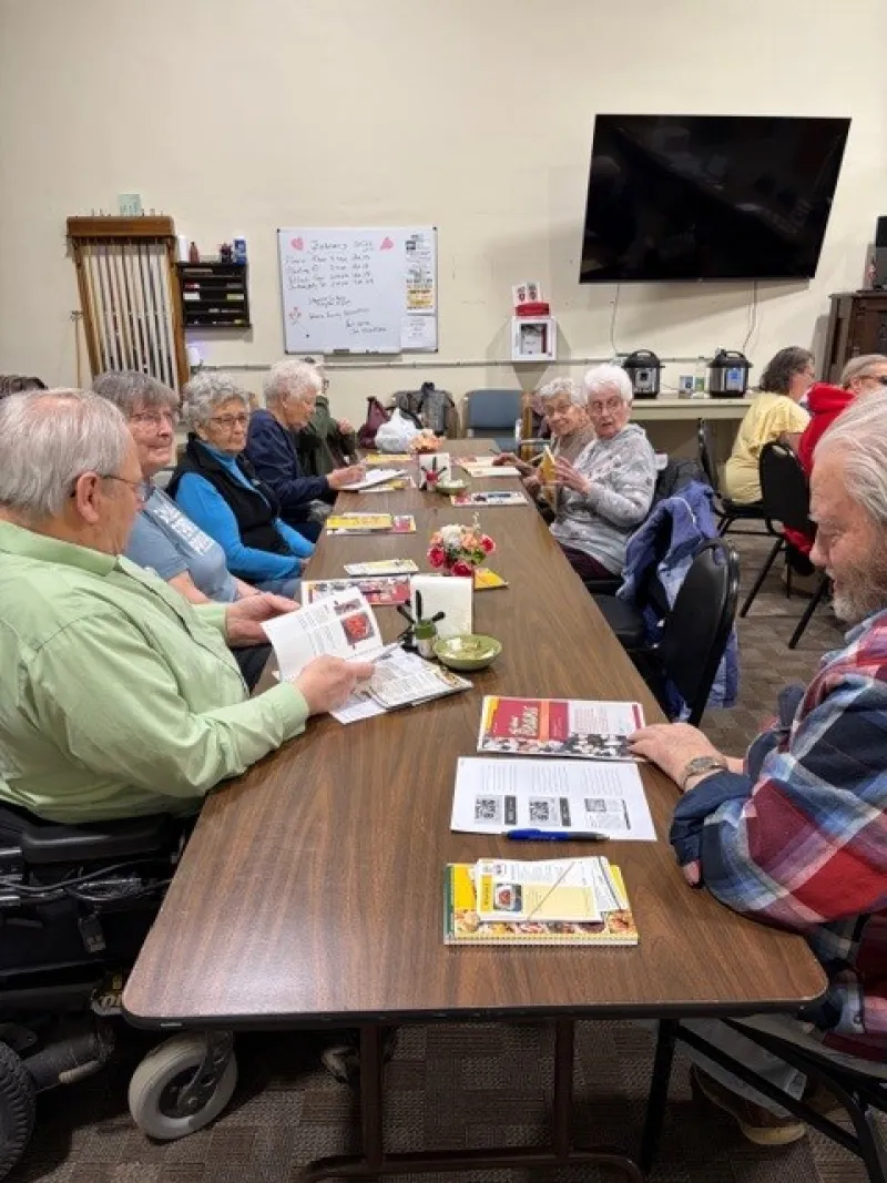 Senior citizens sitting at a table learning about bean nutrition