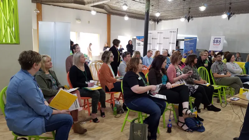 A group of twenty people listening to a speaker