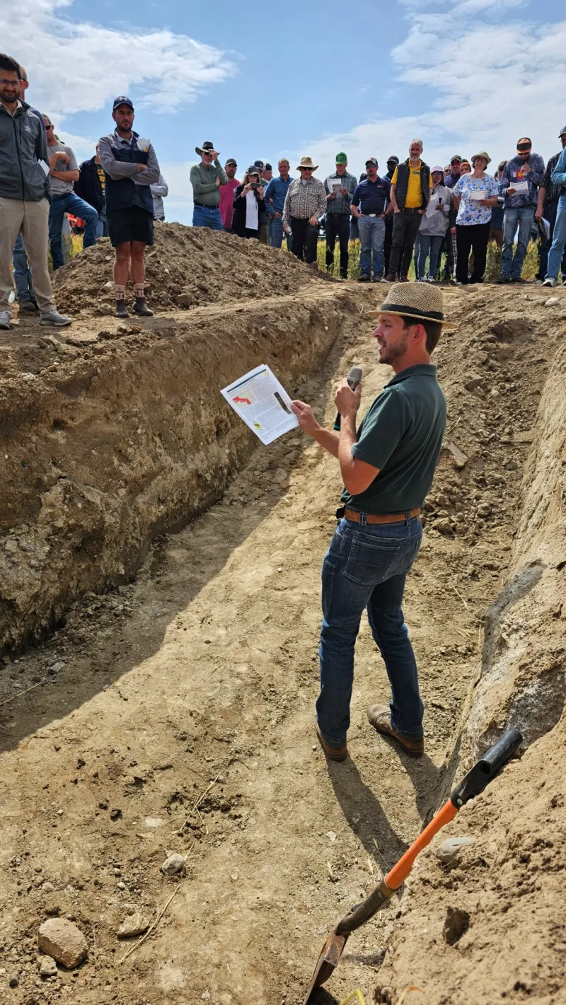 a man in a ditch talking about soil health