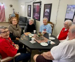 a group of senior citizens visiting around a table at Christmas