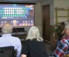 Senior citizens playing Wheel of Fortune game on TV