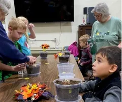 children and senior citizens pot flowers together
