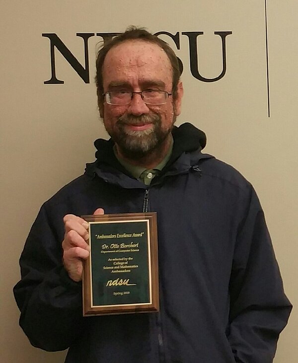 Dr. Otto Borchert holding his Award of Excellence Plaque.